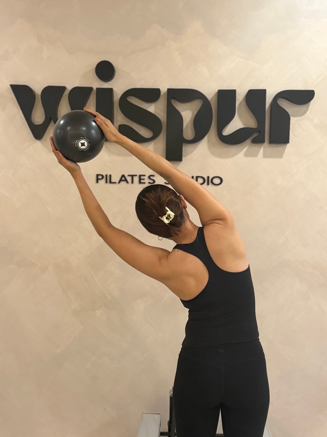 Sheena stretching in front of the Wispur sign